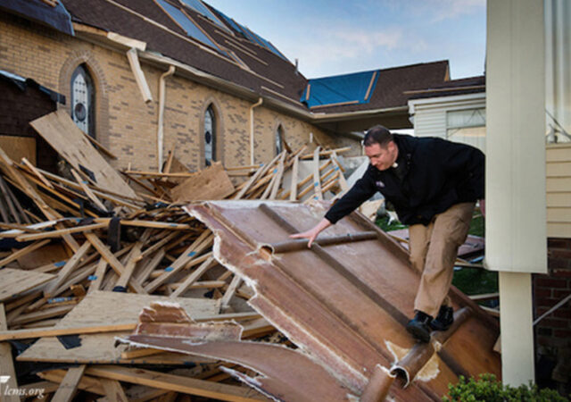 The Rev. Michael Meyer, manager of LCMS Disaster Response, climbs through debris Thursday, May 1, 2014, at Holy Trinity Lutheran Church in Tupelo, Miss. The church suffered catastrophic damage caused by a tornado earlier in the week. LCMS Communications/Erik M. Lunsford