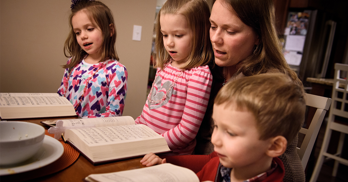 Laurie Vogt sings from the Lutheran Service Book with her children Elizabeth, Abigail (in lap) and Carl during an evening devotion with the Congregation at Prayer resource at their home on Sunday, Feb. 7, 2016, in Menomonee Falls, Wis. LCMS Communications/Erik M. Lunsford