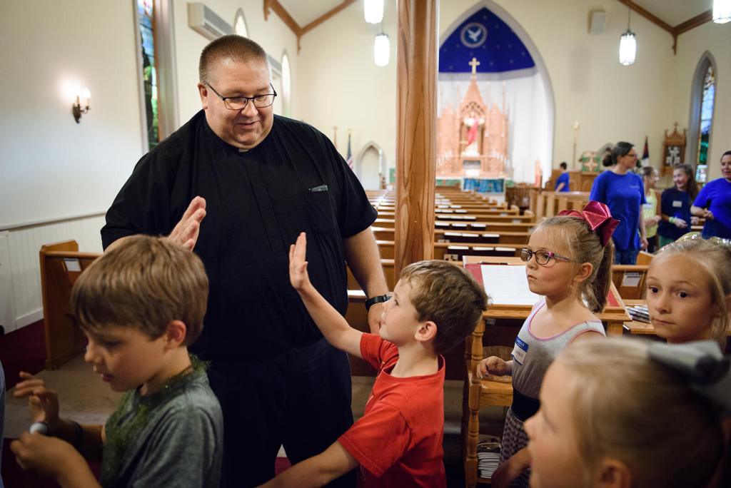The Rev. David Daniel, pastor of Zion, high-fives campers at the end of the day. LCMS COMMUNICATIONS / ERIK LUNSFORD