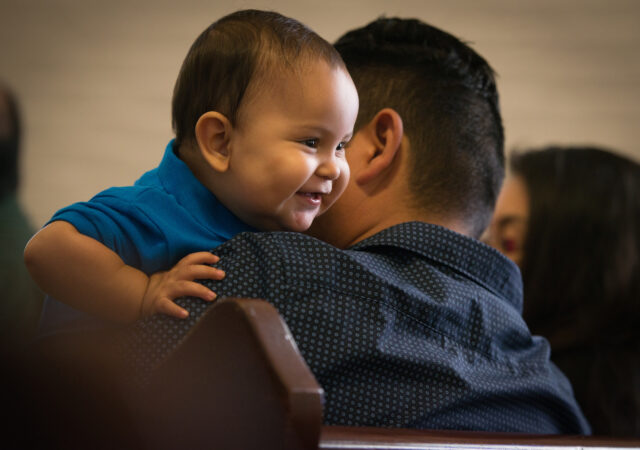 Daniel Anthony Lopez eyes a parishioner behind him as he plays on the lap of his father Daniel Lopez during worship at El Calvario Lutheran Church on Sunday, April 17, 2016, in Brownsville, Texas. LCMS Communications/Erik M. Lunsford
