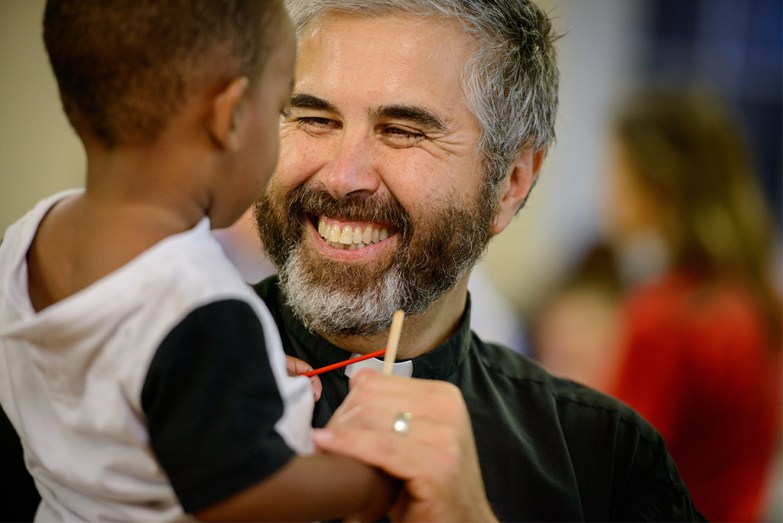 The Rev. John Suguitan plays with Norell Cody during Prince of Peace Lutheran Church’s weekly Wednesday evening devotion service and dinner. LCMS COMMUNICATIONS / ERIK LUNSFORD